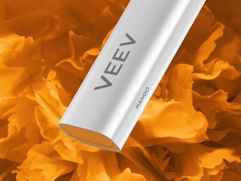 Primer plano de la parte inferior del dispositivo de vapeo VEEV NOW sobre un fondo naranja